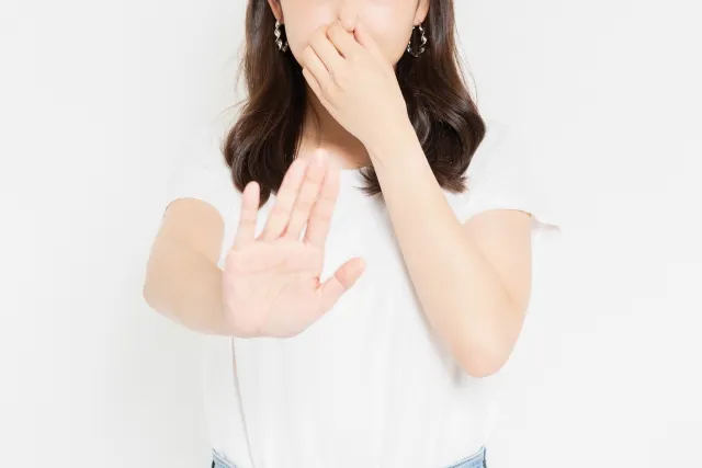 鼻をつまむ女性