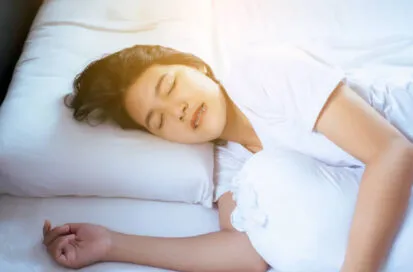寝ているときに歯ぎしりをしている女性