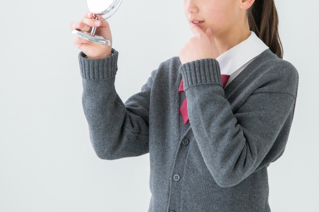 中学生の女の子が歯を気にする様子