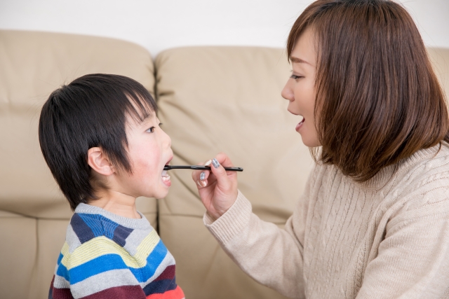 仕上げ磨きをする親子